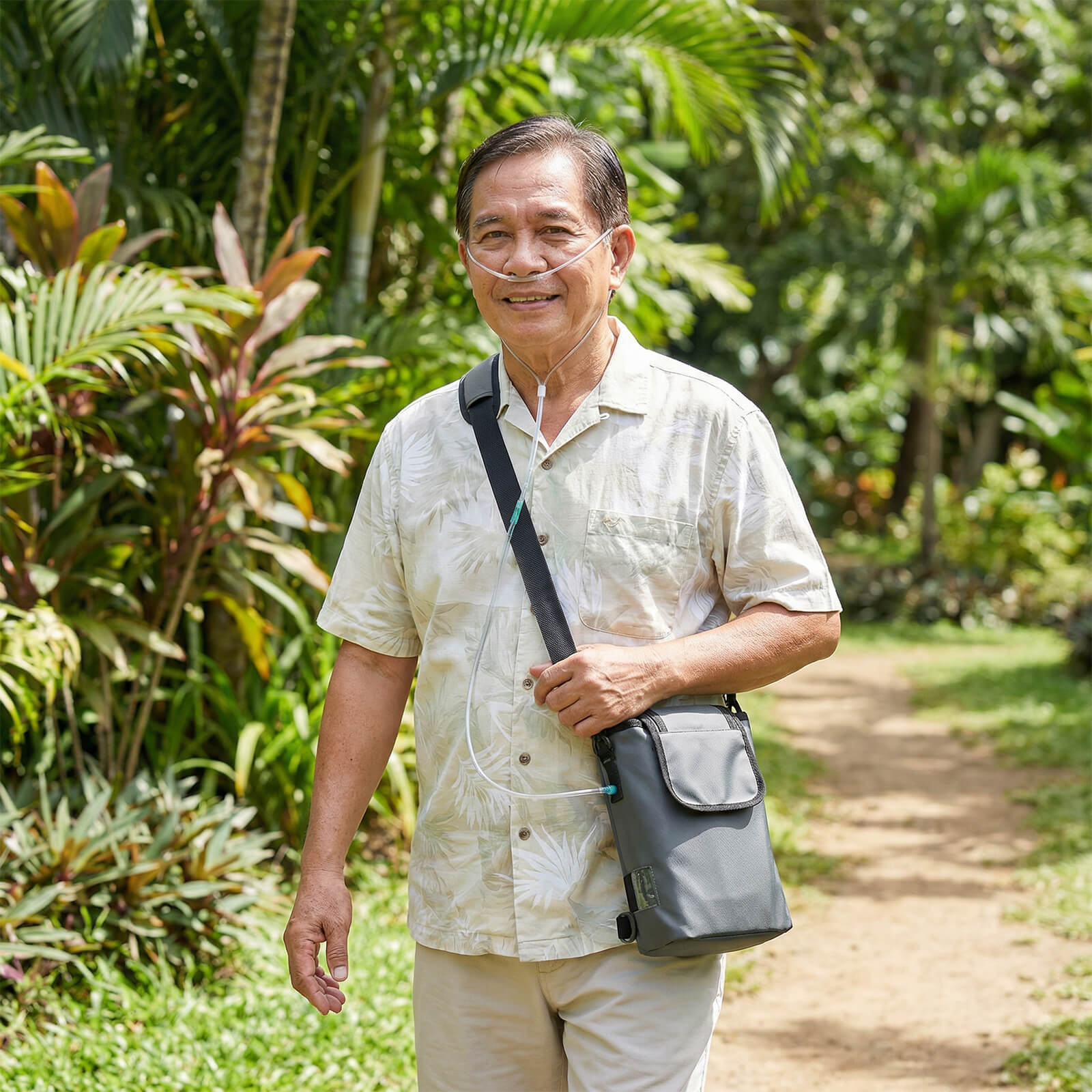 An elderly man walking outdoors while carrying a VP-2 Portable Oxygen Concentrator for active mobility.