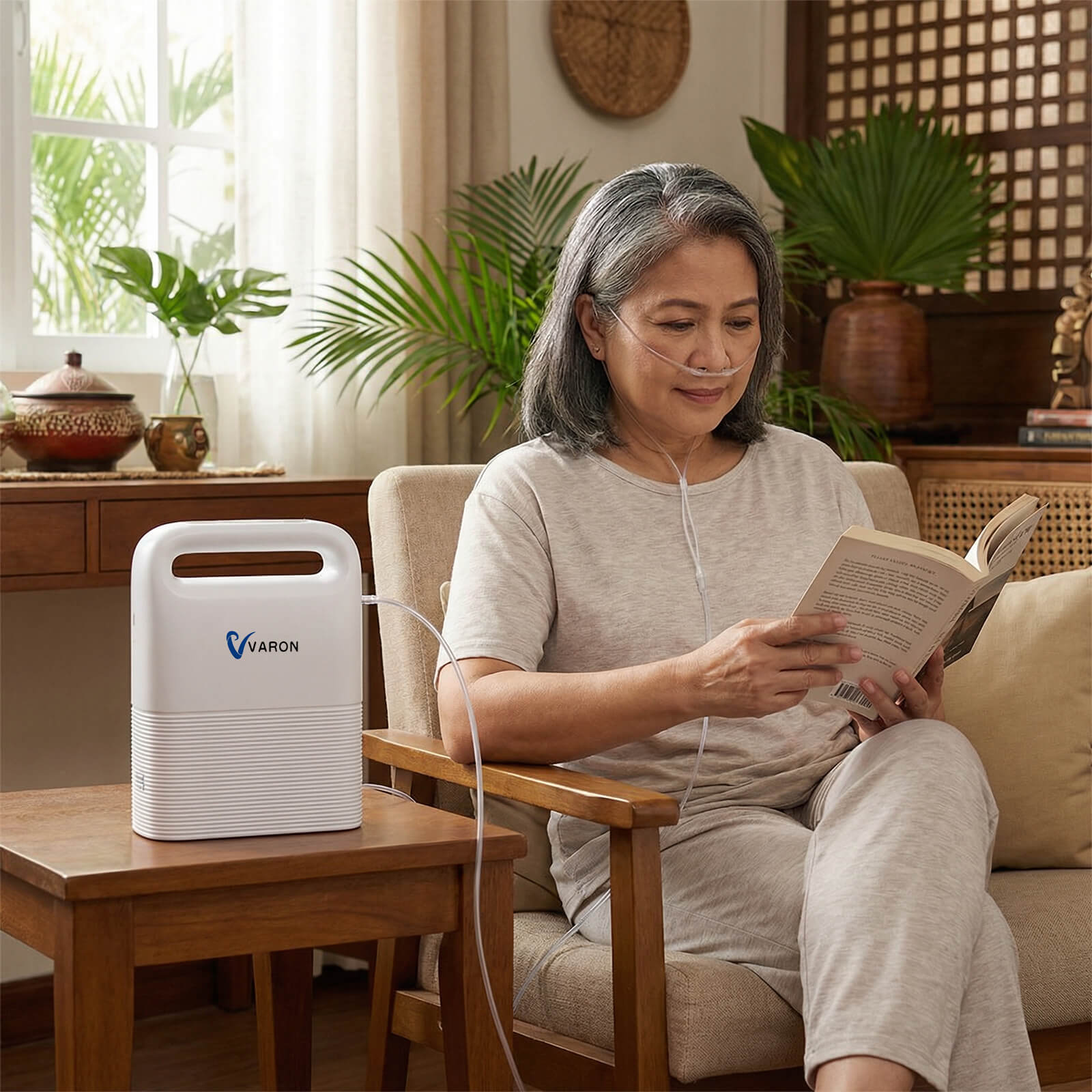 Elderly woman reading on a couch while using a VP-2 Portable Oxygen Concentrator for quiet home therapy.